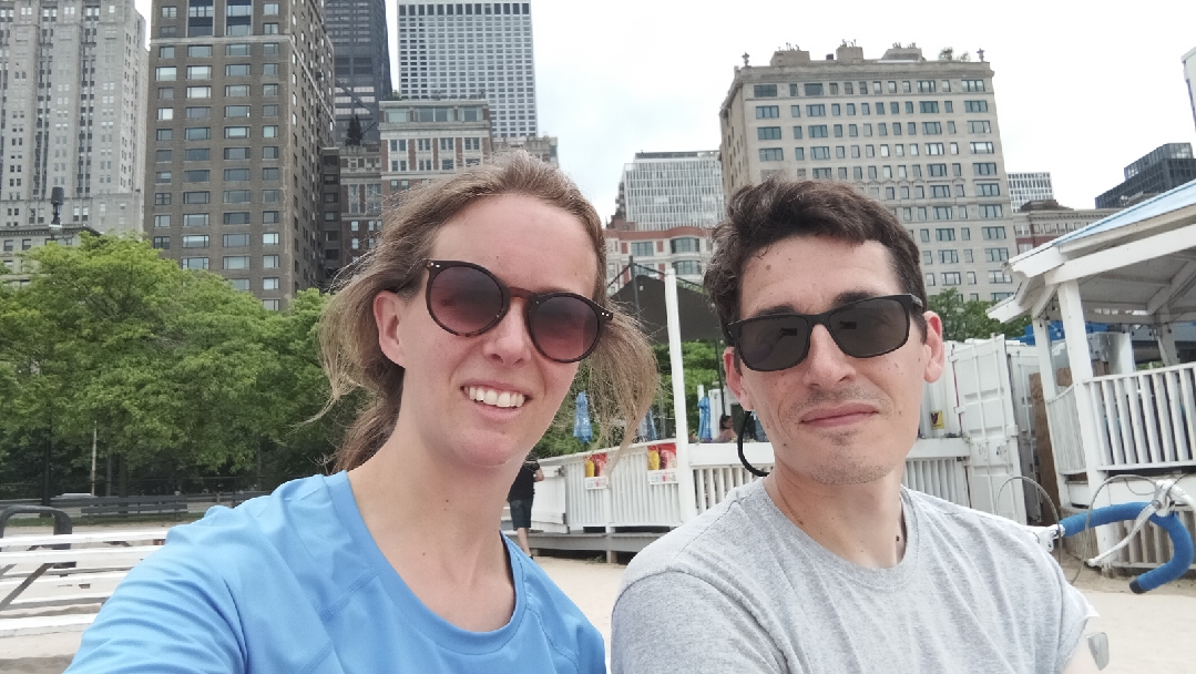 Us wearing sunglasses. Buildings are behind us.